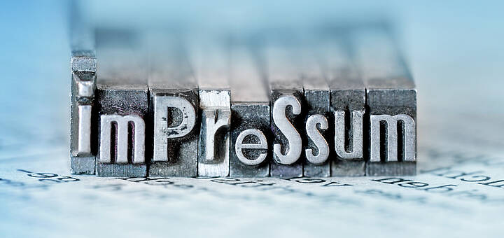 Wort „Impressum“ als Metallstempel dargestellt
