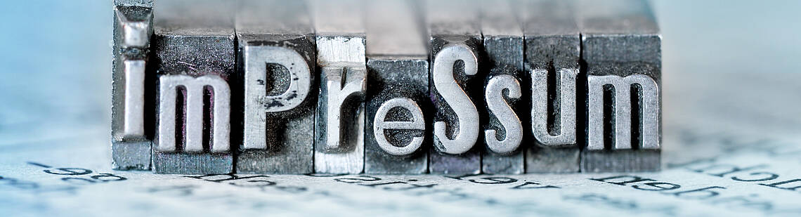 Wort „Impressum“ als Metallstempel dargestellt