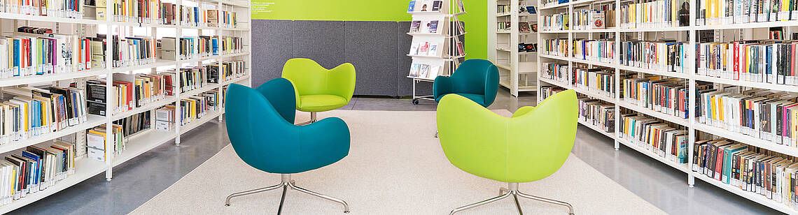 Bücherregale, zwischen denen Sessel stehen