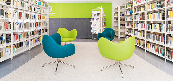 Bücherregale, zwischen denen Sessel stehen