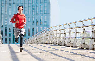 Mann läuft über Brücke