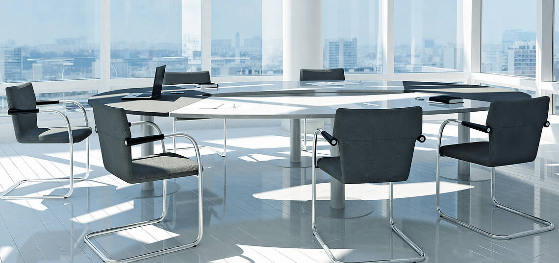 Konferenztisch mit Stühlen in einem modernen Büro mit großen Fensterflächen und Stadtsilhouette im Hintergrund