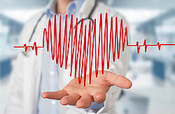 Pulskurve als Herz dargestellt, im Hintergrund ein Arzt